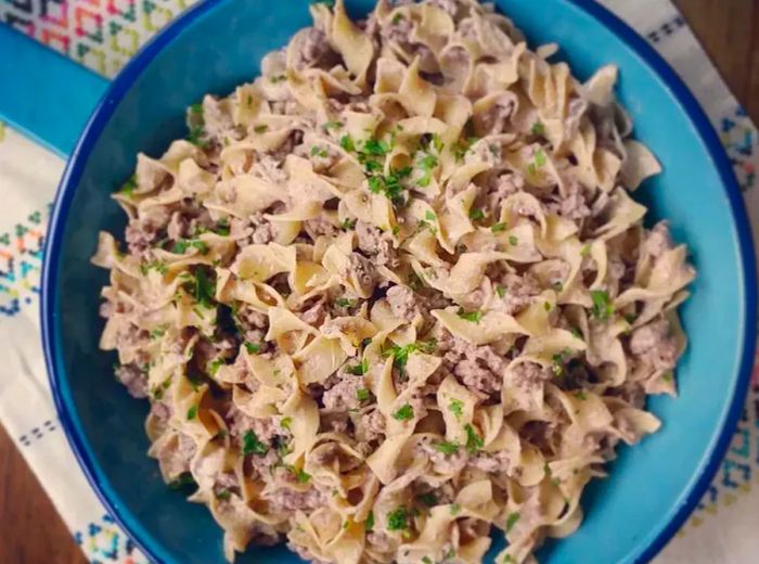 A top-down shot of ground beef stroganoff in a blue skillet