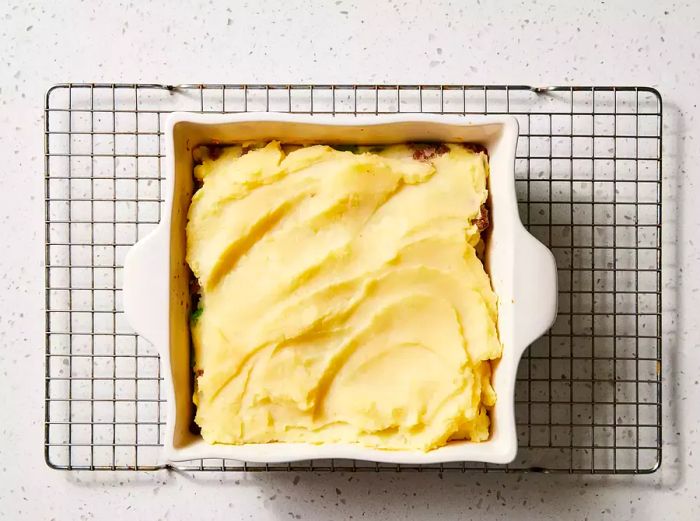 A baking dish filled with the ground beef mixture, topped with a layer of mashed potatoes.