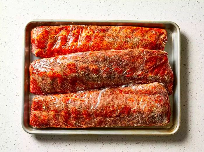 Rub the spice mix generously over the ribs and wrap them in plastic wrap.