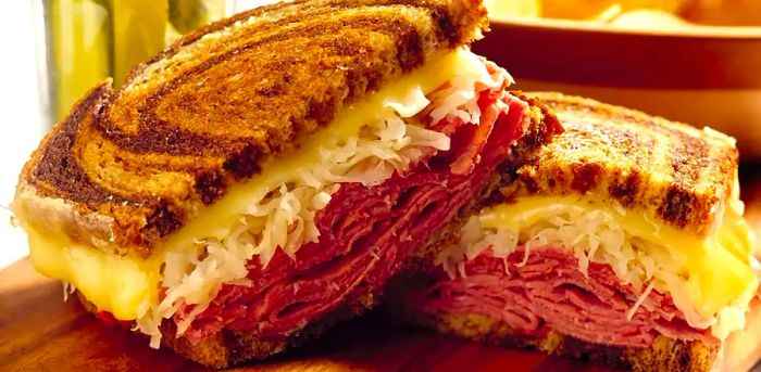 A Reuben sandwich sliced in half, showcasing all the delicious layers inside.