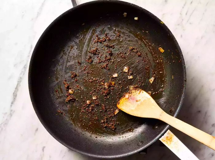 The seasonings toast in the skillet, filling the air with a fragrant aroma.