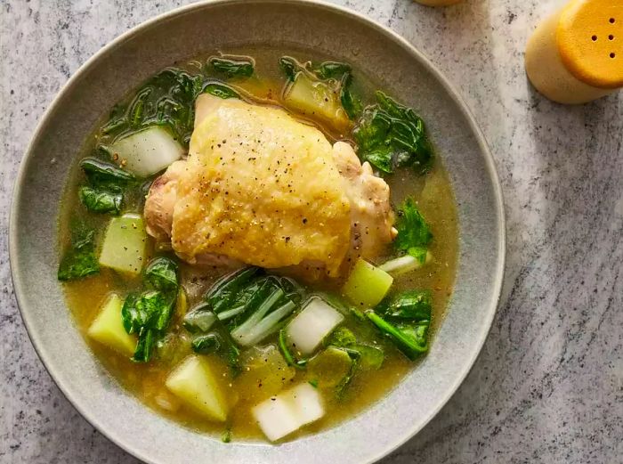 a close-up view of a steaming bowl of chicken tinola.