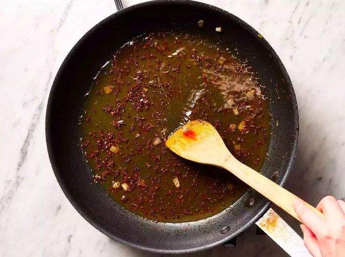 Chicken broth poured into the skillet with the toasted seasonings.