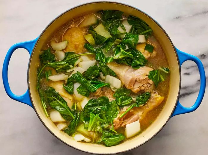 Bok choy and spinach added to the pot, cooking until the spinach is just wilted.