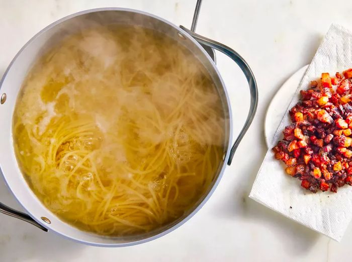 Overhead shot of boiled pasta and guanciale