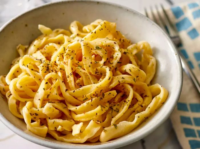 A bowl of egg noodles served in a gray dish