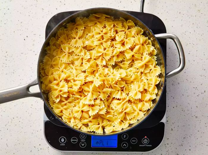 Pasta is stirred into the butter sauce and seasoned with salt and pepper.