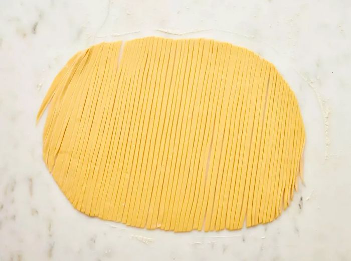 Dough rolled out and sliced into strips