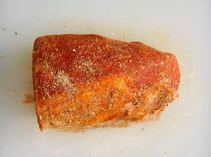 Close-up view of an eye of round roast coated with a flavorful seasoning rub