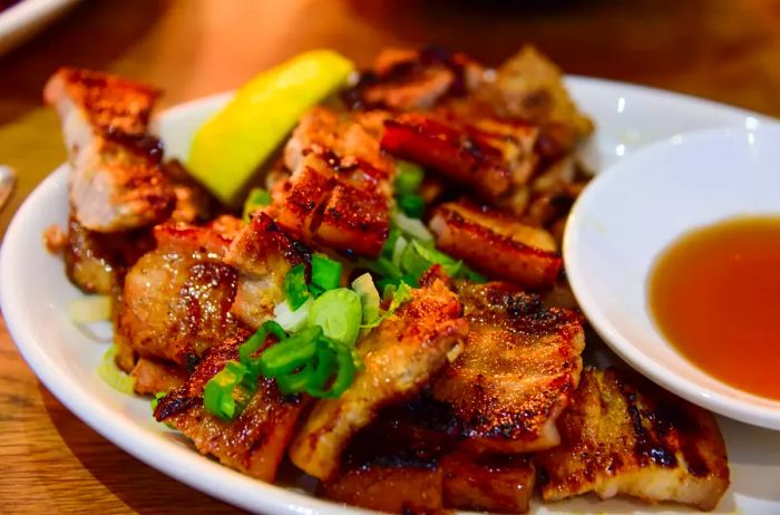 Inihaw Na Liempo, a Filipino dish of marinated pork belly grilled and served with vinegar.