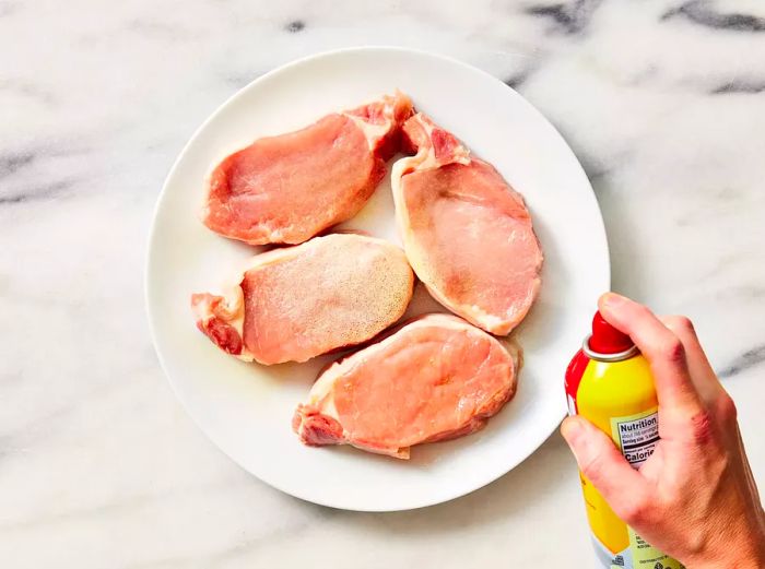 Pork chops coated with a light spray of cooking spray.