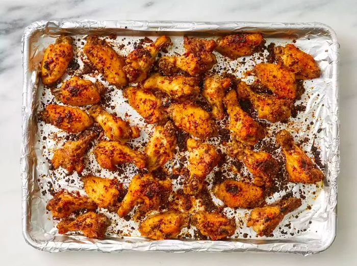 Crispy, golden brown chicken wings on a foil-lined baking sheet