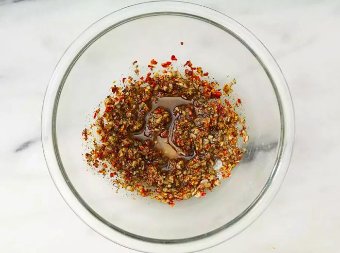 A bowl filled with seasoned oil and spices