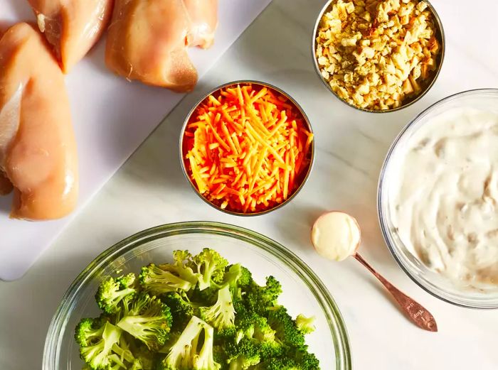 A bird's-eye view of the chicken casserole ingredients, arranged in various bowls and containers.