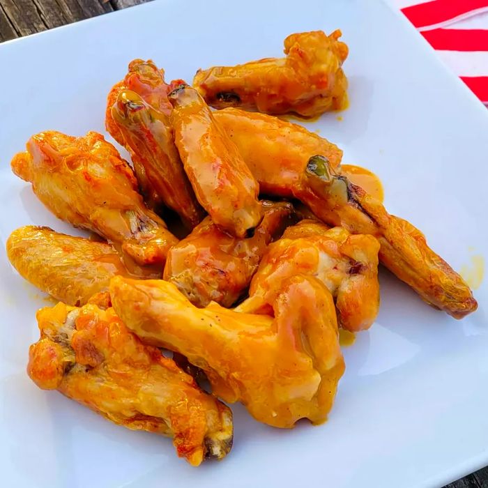 Close-up shot of Sweet Hot Mustard Chicken Wings served on a white plate.