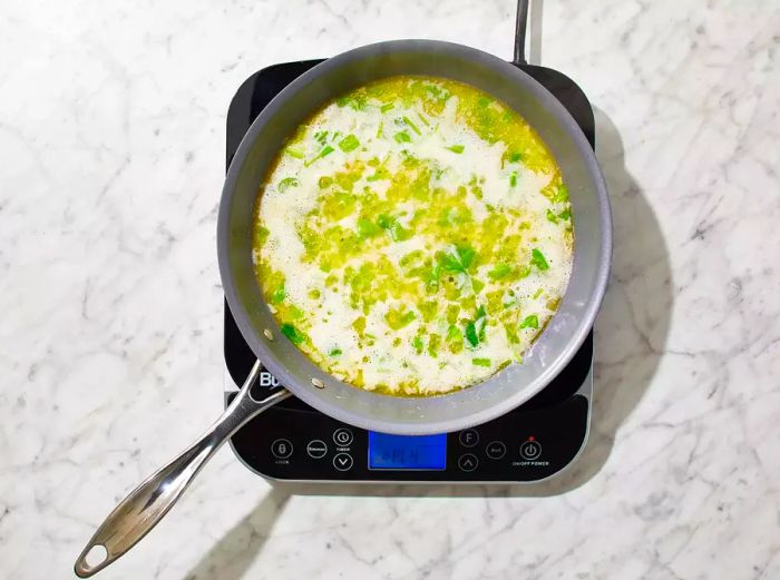 Onion and celery sautéing in hot butter in a skillet.