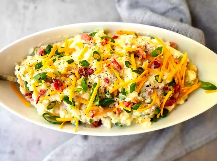 Creamy loaded mashed potatoes topped with melted cheese and fresh scallions