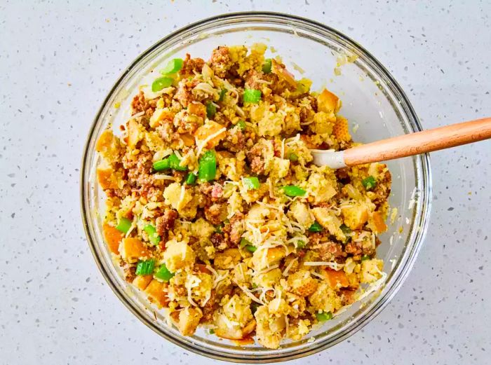 A large mixing bowl of stuffing with French bread, sausage, and parmesan cheese