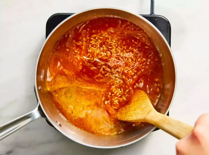 Water is gradually added, along with tomato, onion, and garlic powders.