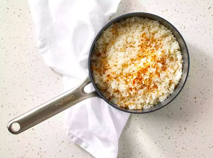 Sweet Coconut Rice resting in a pot on the kitchen counter