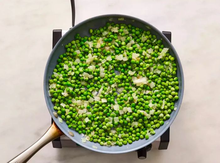 Frozen peas and stock cooking in the skillet until tender.