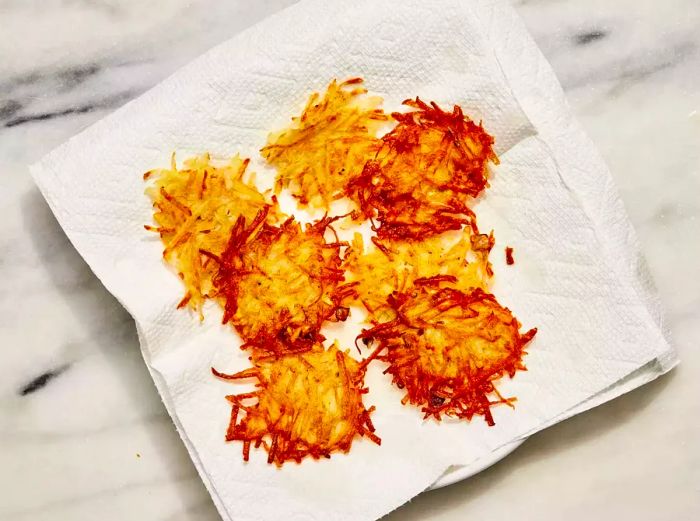 A plate lined with paper towels holding golden German potato pancakes