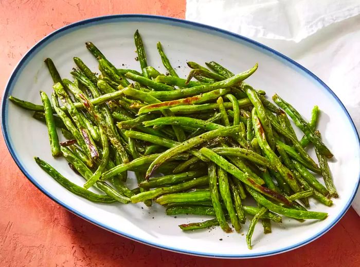 Overhead view of a large platter of roasted green beans