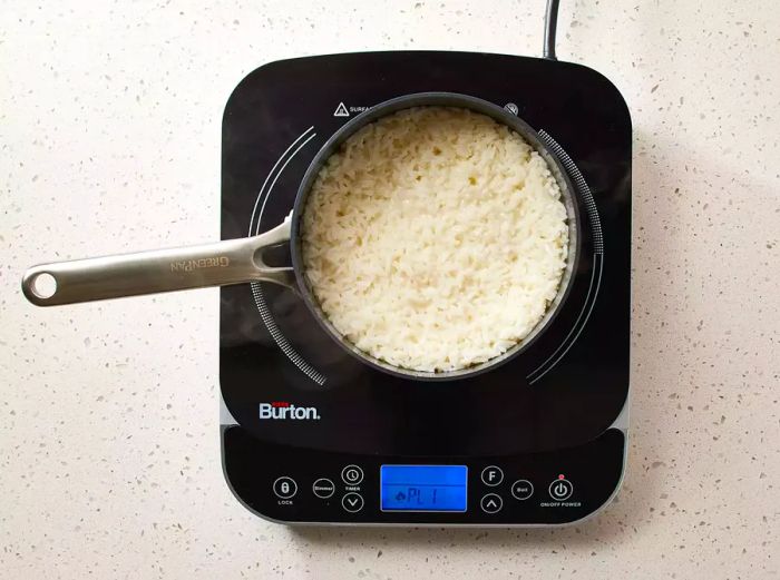 Sweet Coconut Rice simmering in a saucepan on the stove