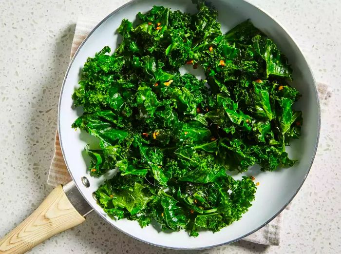 An overhead shot of garlic kale cooking in a skillet.