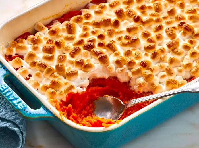 Sweet potato casserole with marshmallows, served in a casserole dish.