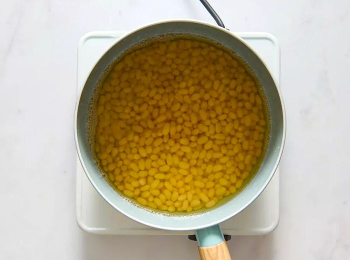 Beans soaking in water on the stovetop, ready for cooking.