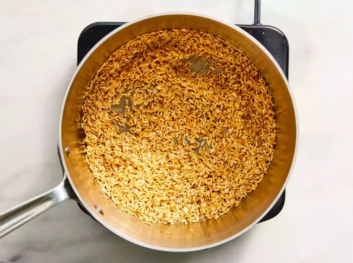 Cook the rice in a saucepan until it turns golden brown.