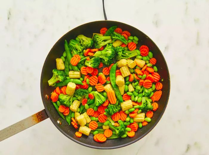 Veggies cooking in a skillet.