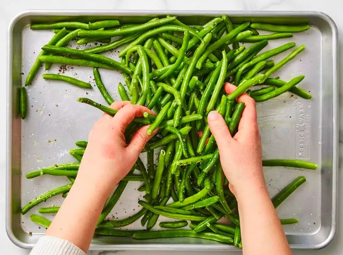 Green beans tossed in seasoning and oil to coat evenly