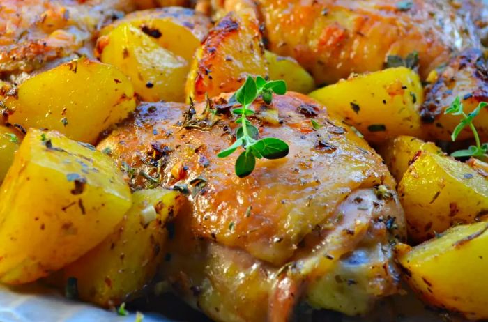 Greek Lemon Chicken with Potatoes, topped with a fresh herb garnish.