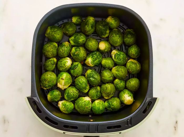 Brussels sprouts spread out in the air fryer basket