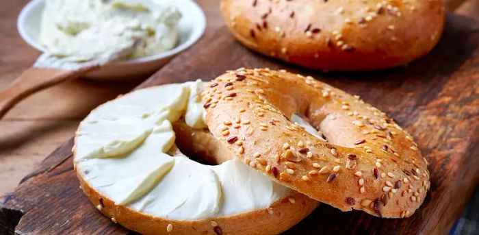 Bagel with cream cheese on a wooden surface