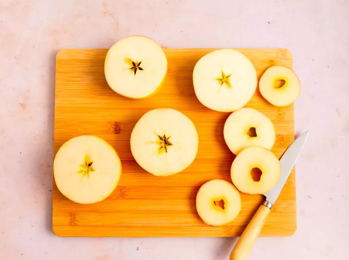 Sliced apples on a wooden cutting board.