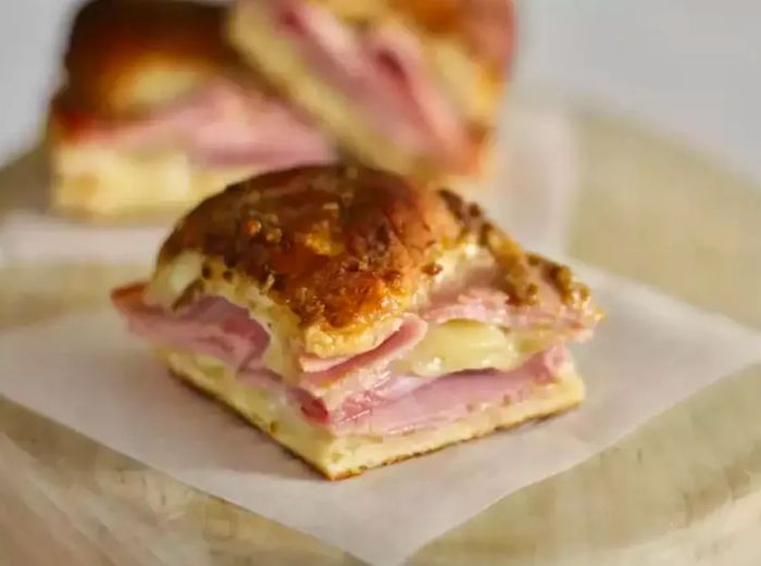 A warm baked slider made with a Hawaiian roll, filled with ham and gooey melted cheese.