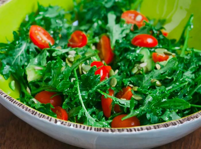 A low-angle close-up of a fresh, vibrant bowl of easy arugula salad.