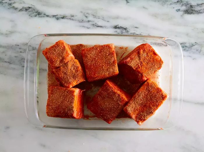 Aerial view of ribs resting in a baking dish, covered with a flavorful spice rub.