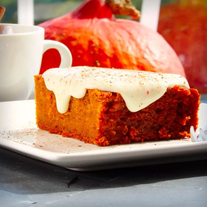 Pumpkin Squares served on a white plate, with a pumpkin and white mug in the background