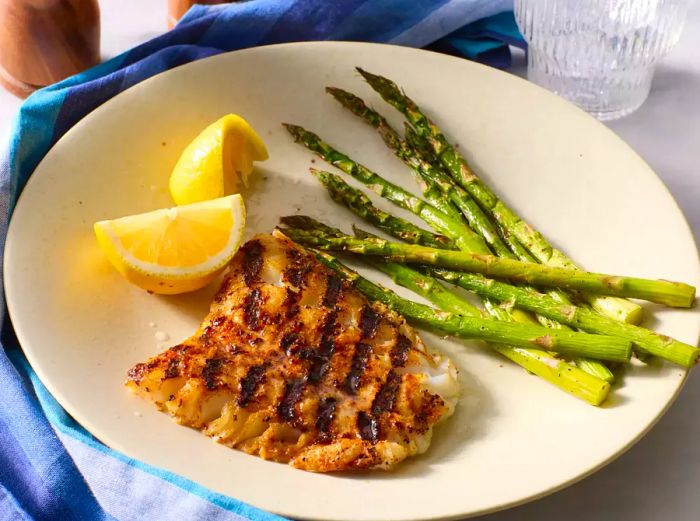 grilled cod plated with a side of fresh asparagus