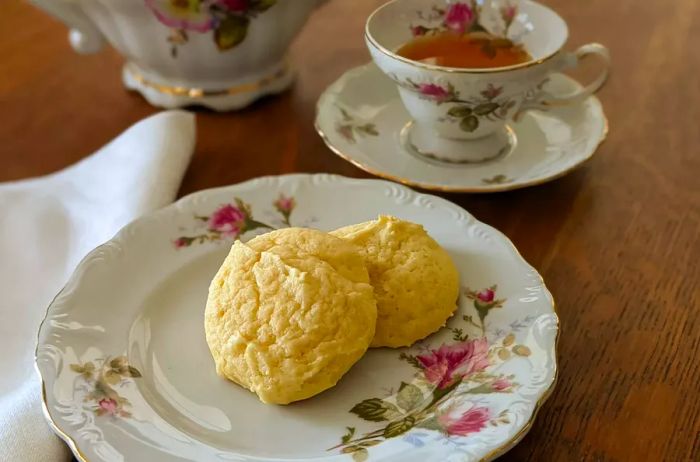 A plate of Great-Grandma's Sour Cream Drop Cookies paired with a cup of tea