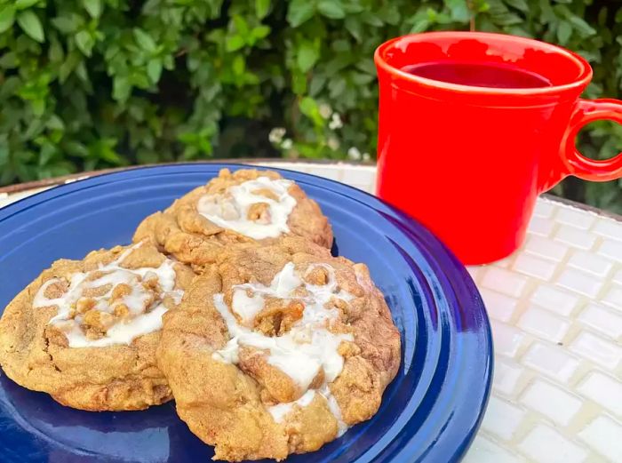 A plate of coffee cake cookies alongside a steaming cup of coffee.