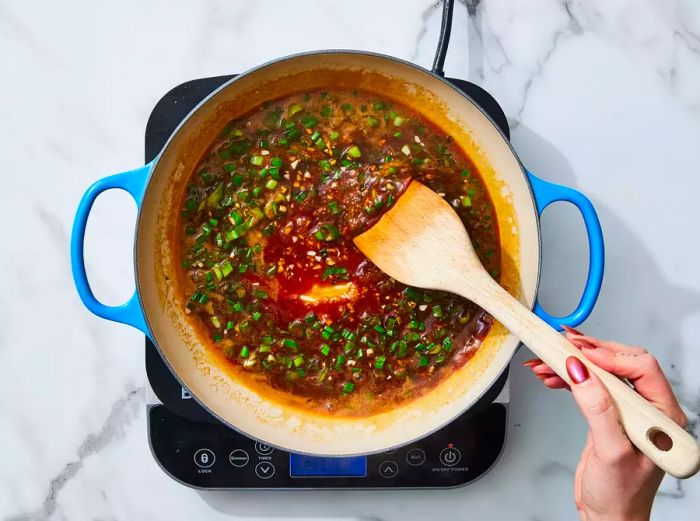 Butter, soy sauce, green onions, and garlic simmering in a skillet