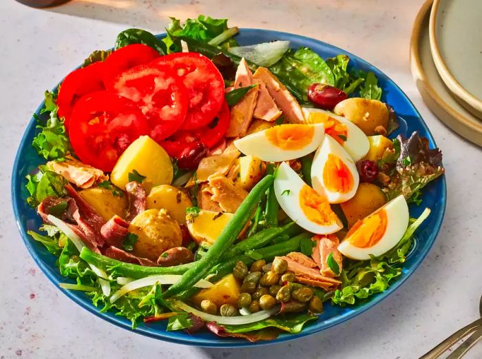 Salad Niçoise presented on a blue platter.