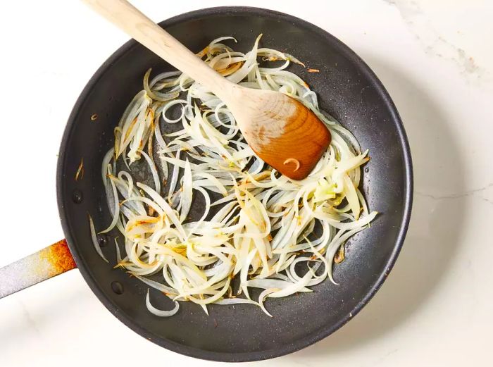 Onions sautéing in oil until golden and soft.