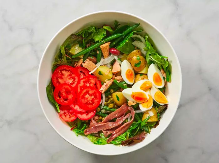 Salad Niçoise served in a white bowl.