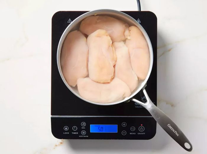 A pot filled with chicken and water